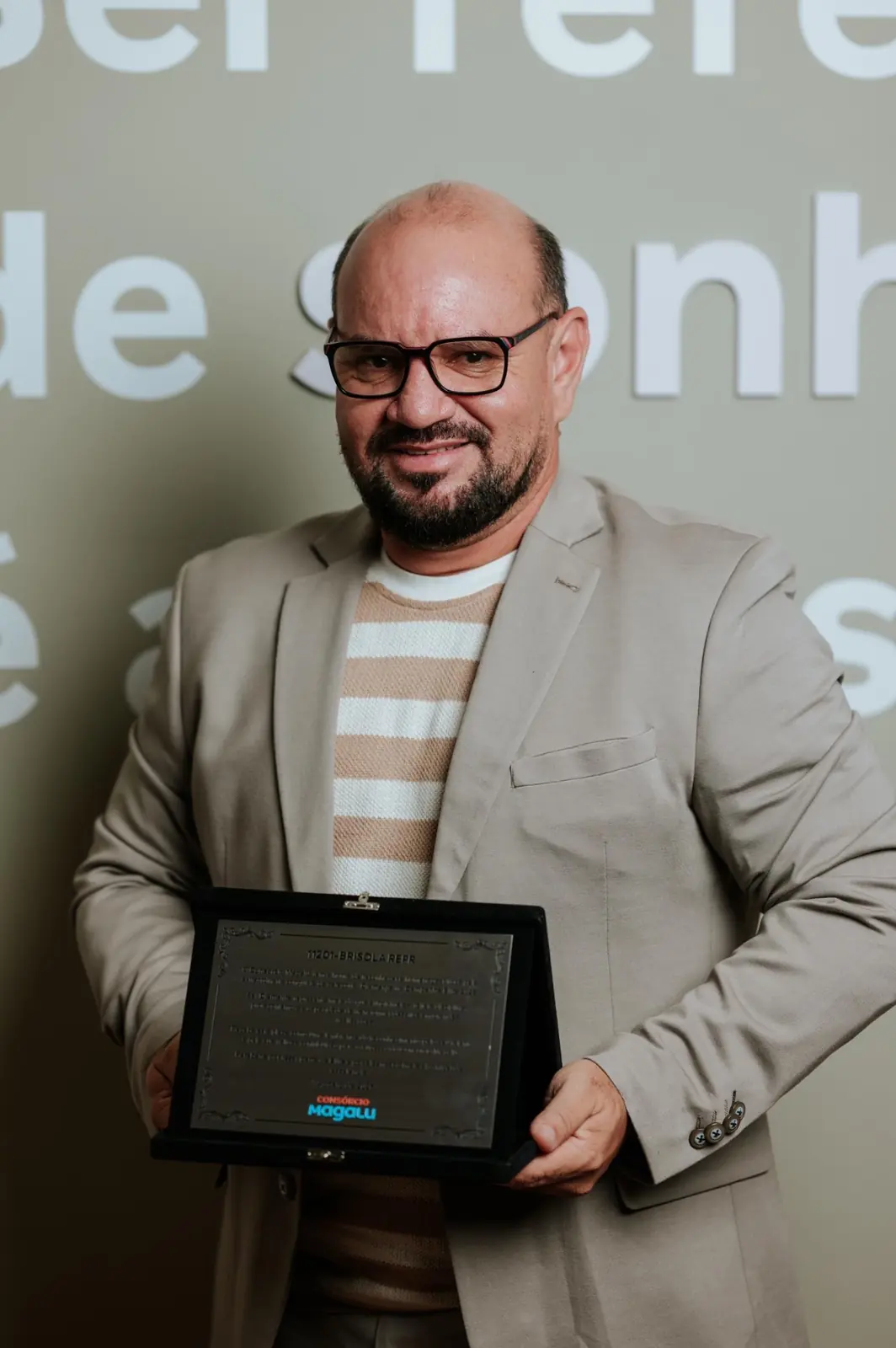 Rones Amorim segurando a placa de reconhecimento da categoria Diamante na Campanha Elite 2026 da Magalu